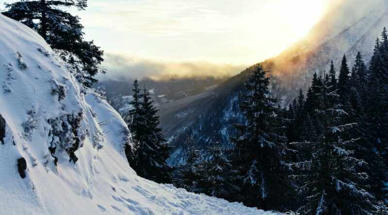 the sun is shining through the clouds over the mountains