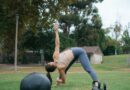 woman in white tank top and gray leggings doing push up on black exercise ball on near near near near