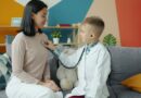 Boy in doctor's coat listens to mother's chest